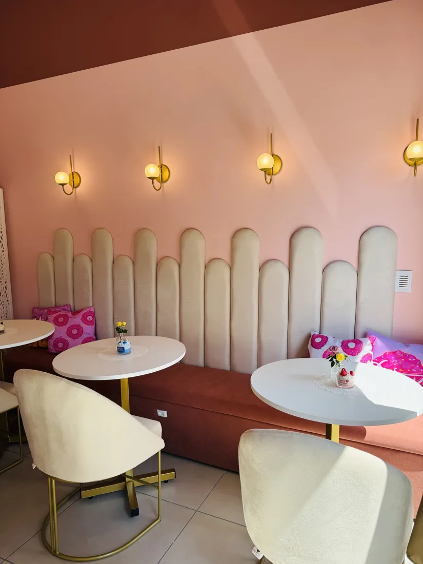 Banco estofado com almofadas de donut e cadeiras de veludo creme